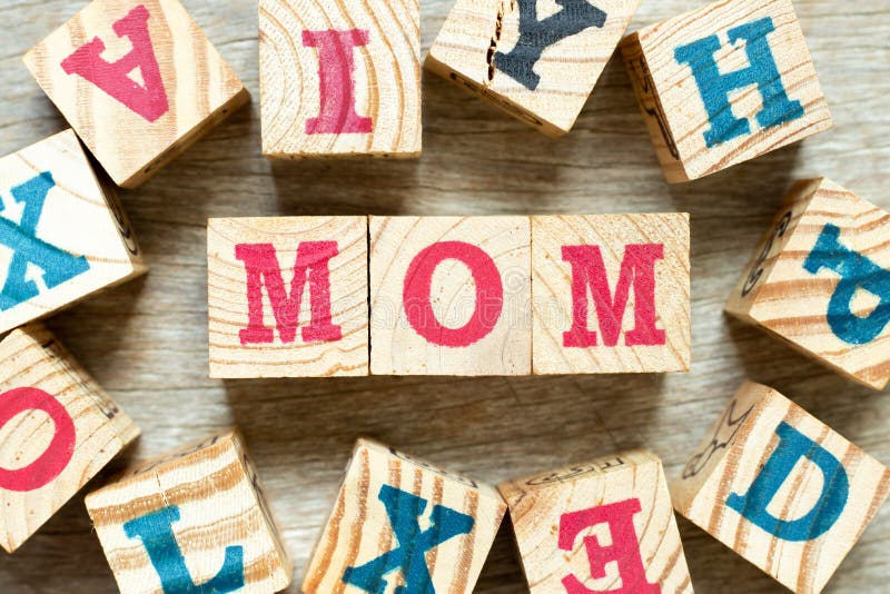 Alphabet letter block in word mom with another on wood background