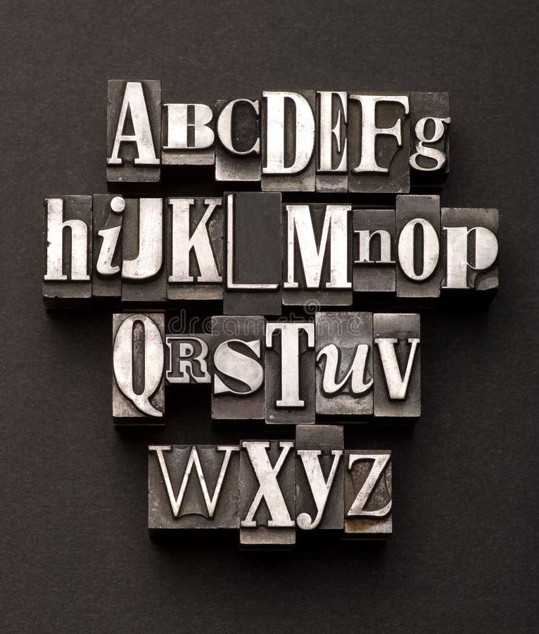 Alphabet fotografiert mit einem mix aus vintage-hoch-Zeichen auf einem schwarzen, strukturierten hintergrund.