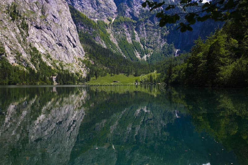 Alpi alpine del lago in primavera Vista della riva dalla capanna del lago alpino Riflessione delle montagne nel cristallino immagine stock libera da diritti Alpi alpine del lago in primavera Vista della riva dalla capanna del lago alpino Riflessione delle montagne nel cristallino immagine stock libera da diritti