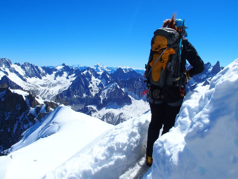 AIGUILLE DU MIDI, FRANCE EUROPE on JULY 2016: Alpinist, mountaineer climber in french ALPS at CHAMONIX MONT BLANC, top alpine mountains range landscape with clear blue sky in warm sunny summer day.