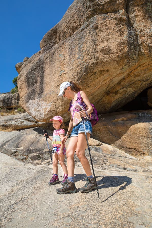 Alpinistes mère et fille avec des bâtons de randonnée en montagne rocheuse