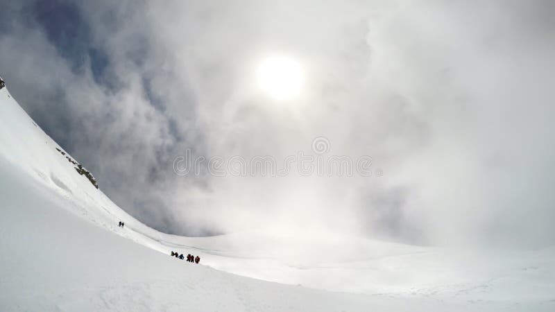 Alpinists and mountaineer climbers in french Alps and high alpine mountains range on AIGUILLE DU MIDI in CHAMONIX MONT BLANC with clear blue sky in warm sunny summer day