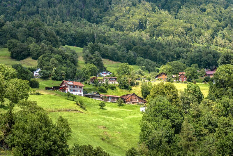 Alpregionernas landskap i byarna i Schweiz. Landskap på alperna och kulturlandskap på sommaren arkivfoton