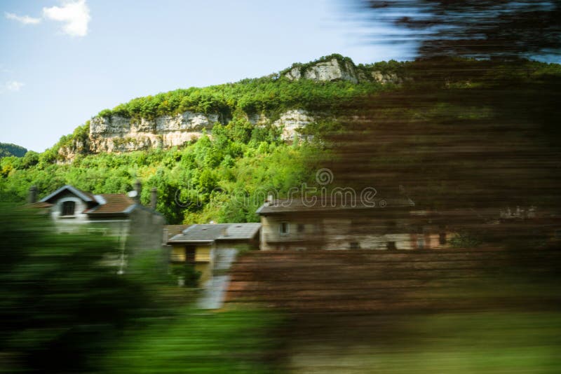 Alps mountains and hidden house seen from fast train in motion royalty free stock photography Alps mountains and hidden house seen from fast train in motion royalty free stock photography