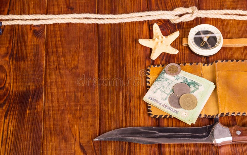 Alt, Kompass, Geld, Messer und Starfish auf Hintergrunddunkelheitsholz