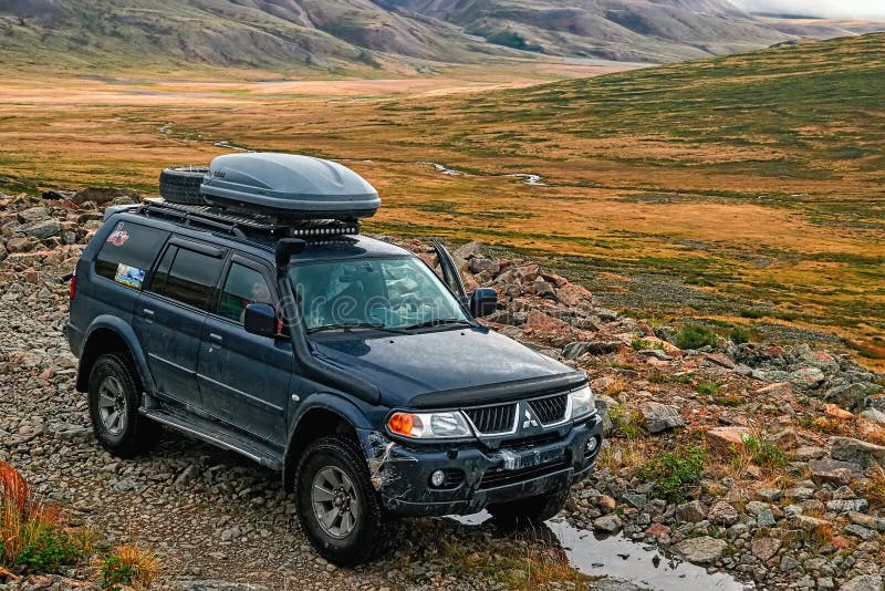 ALTAI, РОССИЯ - 12-ОЕ АВГУСТА 2015: Внедорожный корабль на плато Ukok горы Передний бампер автомобиля поврежден стоковое фото