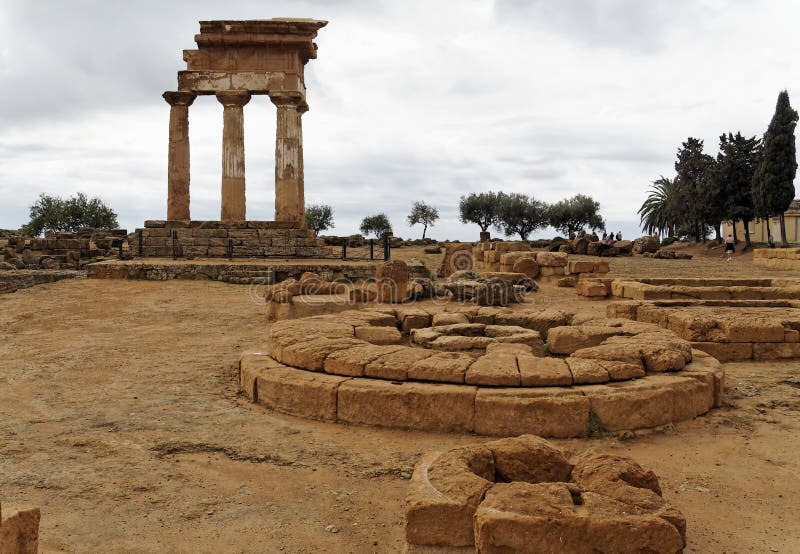 Temple Valley, Agrigento, Sicily, Italy. The circular altar of sacrifices in front of the ruins of the greek Temple of Castor and Polux. The temple has four doric columns. Temple Valley, Agrigento, Sicily, Italy. The circular altar of sacrifices in front of the ruins of the greek Temple of Castor and Polux. The temple has four doric columns.