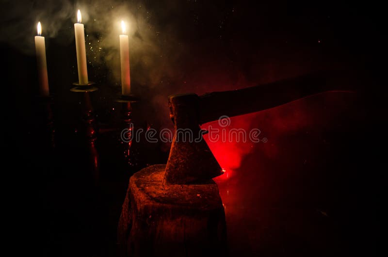 Alte Axt befestigt zum Baumstamm auf rotem nebeligem Hintergrund des Horrors Furchtsames Halloween-Thema mit Wahnsinnigemörderwaf stockfoto Alte Axt befestigt zum Baumstamm auf rotem nebeligem Hintergrund des Horrors Furchtsames Halloween-Thema mit Wahnsinnigemörderwaf stockfoto