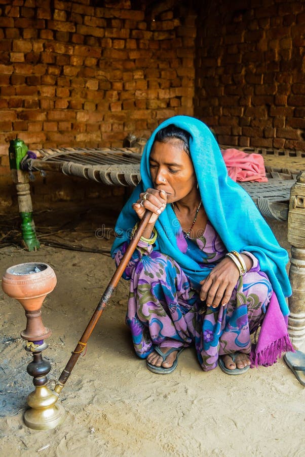 Old Village lady in India wearing traditional attire having hukka. Old Village lady in India wearing traditional attire having hukka