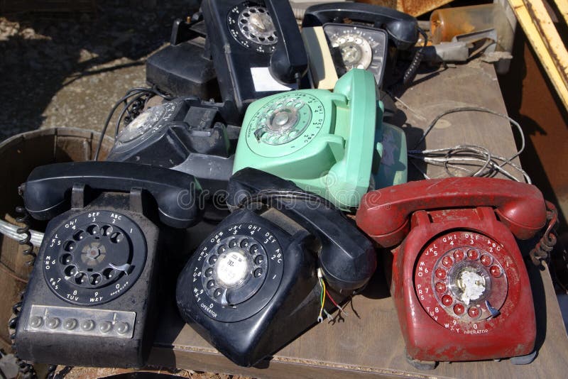 Stack of old broken rotary telephones on table. Stack of old broken rotary telephones on table.