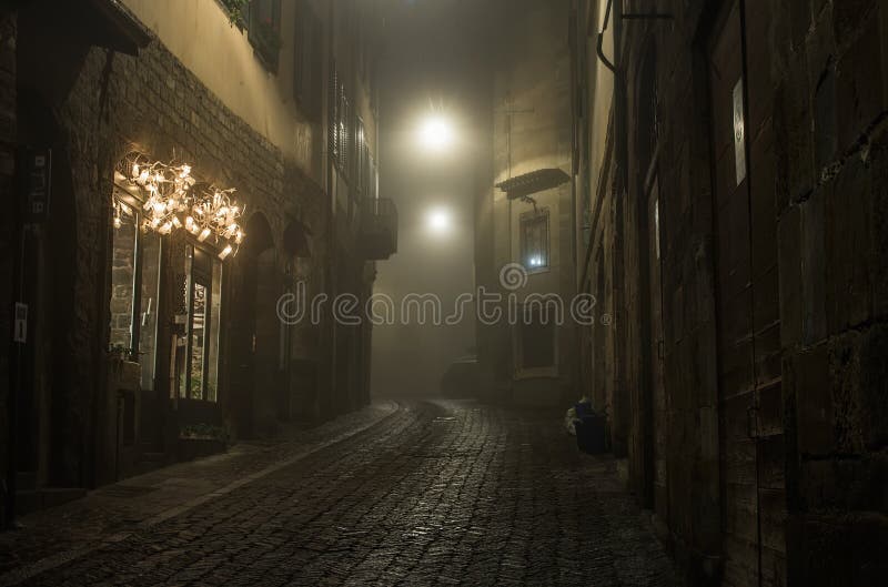 Old European narrow empty street of a medieval town on a foggy evening. Taken in Bergamo, Citta Alta. Old European narrow empty street of a medieval town on a foggy evening. Taken in Bergamo, Citta Alta