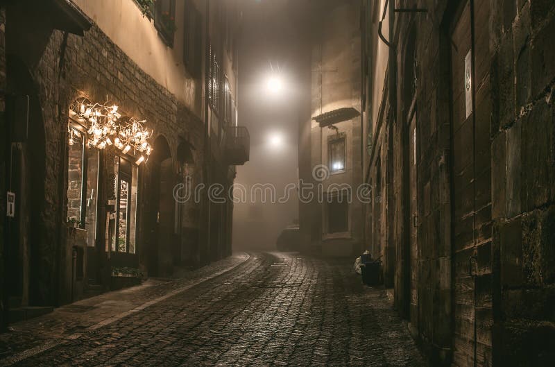Alte europäische schmale leere Straße der mittelalterlichen Stadt an einem nebeligen Abend Eingelassenes Bergamo, Citta Alta, Lom