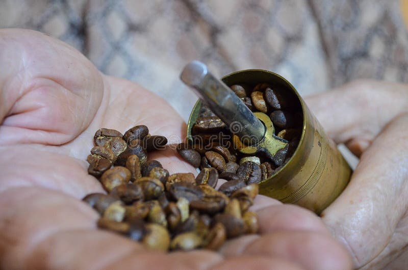 Alte Kaffeemühle und Handdummkopf von Kaffeebohnen lizenzfreie stockfotografie Alte Kaffeemühle und Handdummkopf von Kaffeebohnen lizenzfreie stockfotografie