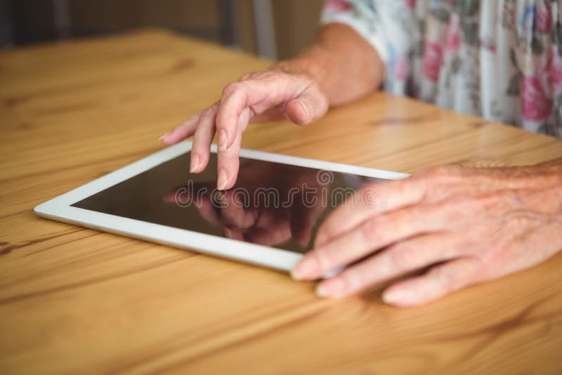 Alte Person, die eine digitale Tablette berührt lizenzfreie stockbilder Alte Person, die eine digitale Tablette berührt lizenzfreie stockbilder