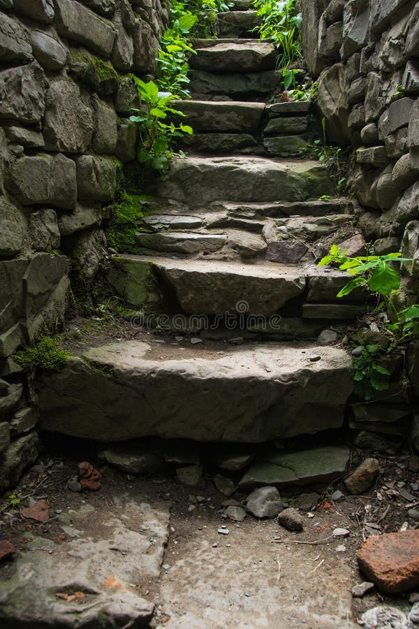 Photo of the Old narrow stone stairs with brick wall. Explore concept. Photo of the Old narrow stone stairs with brick wall. Explore concept