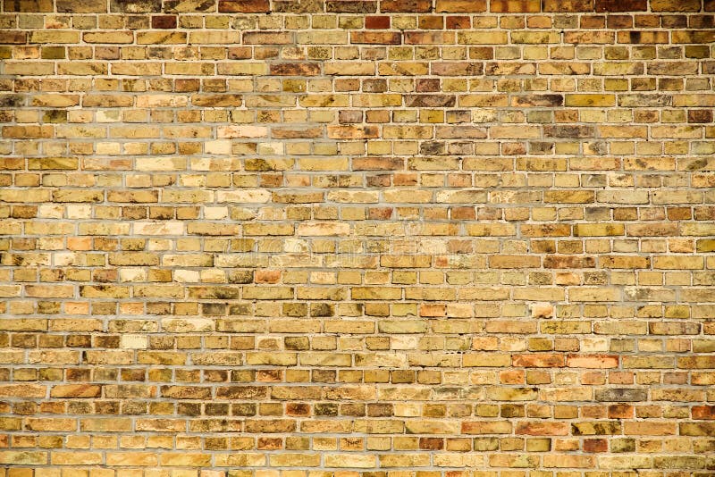 Alte und verwitterte grungy Gelb- und Backsteinwand als nahtloser Musterbeschaffenheitshintergrund lizenzfreie stockbilder