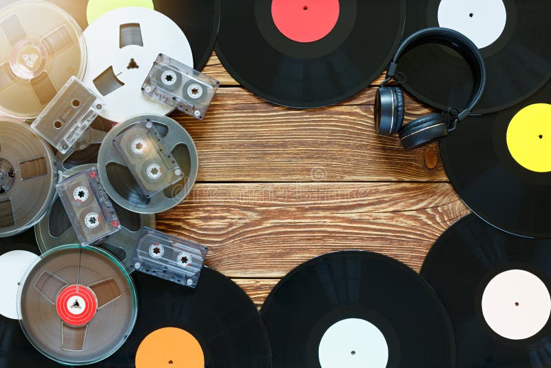 Alte Vintage-Bobbinen, Schallplatten, Kassetten und Kopfhörer auf Holztisch-Hintergrund Mehrfarbige Etiketten Oberansicht Ort stockbilder Alte Vintage-Bobbinen, Schallplatten, Kassetten und Kopfhörer auf Holztisch-Hintergrund Mehrfarbige Etiketten Oberansicht Ort stockbilder