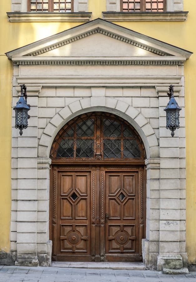 Alte Weinleseholztüren in einem alten Architekturgebäude mit Weinleseschmiedeeisenlaternen lizenzfreies stockfoto Alte Weinleseholztüren in einem alten Architekturgebäude mit Weinleseschmiedeeisenlaternen lizenzfreies stockfoto