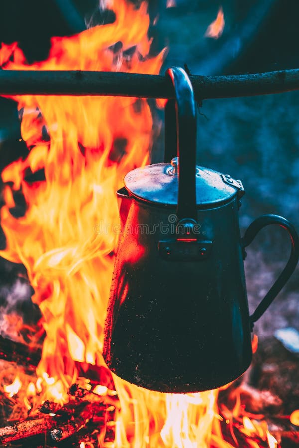 Alter Eisen-Lager-Kessel kocht Wasser auf einem Feuer in Forest Bright Flame Fire Bonfire nachts Dämmerung lizenzfreie stockfotografie Alter Eisen-Lager-Kessel kocht Wasser auf einem Feuer in Forest Bright Flame Fire Bonfire nachts Dämmerung lizenzfreie stockfotografie
