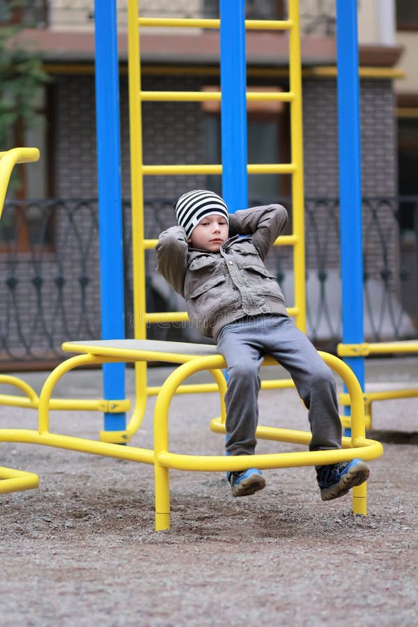 Alter Fünfjahresjunge, der in der Straße, in der Turnhalle im Freien im Yard auf dem Spielplatz ausarbeitet lizenzfreie stockfotografie Alter Fünfjahresjunge, der in der Straße, in der Turnhalle im Freien im Yard auf dem Spielplatz ausarbeitet lizenzfreie stockfotografie