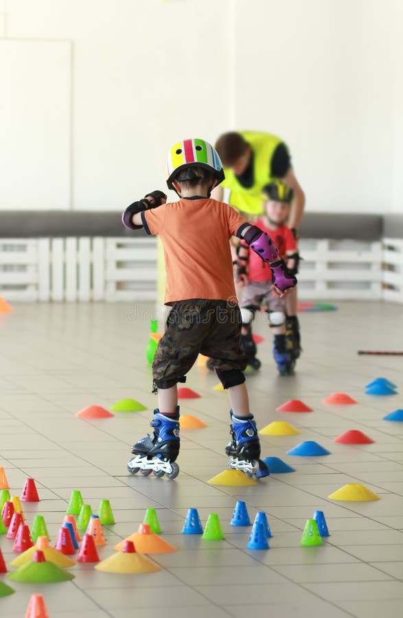 Alter Fünfjahresjunge in einem Sturzhelm lernen Freistil Rollerbladeslalom stockbild Alter Fünfjahresjunge in einem Sturzhelm lernen Freistil Rollerbladeslalom stockbild