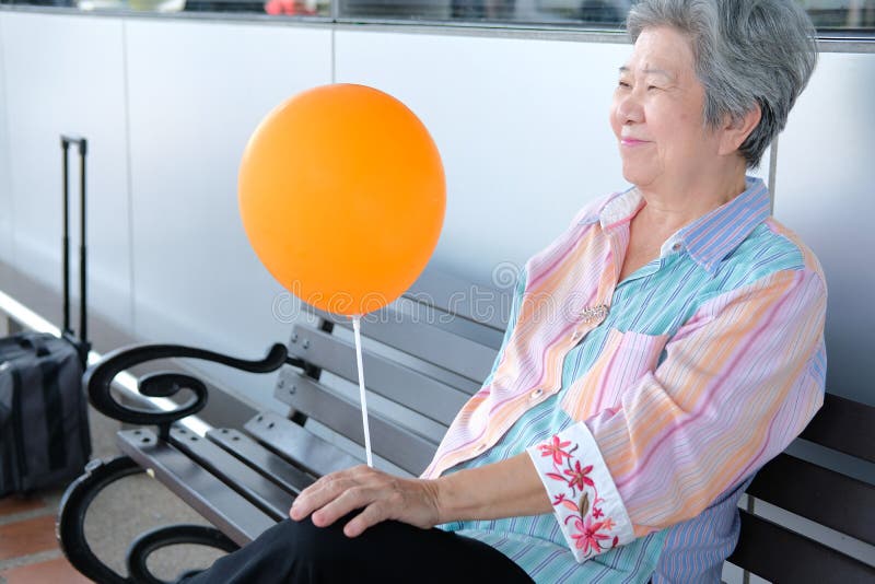 Alter Holdingballon der ?lteren Frau asiatische ?ltere Frau, die sich drau?en entspannt ?lterer Lebensstil lizenzfreie stockbilder Alter Holdingballon der ?lteren Frau asiatische ?ltere Frau, die sich drau?en entspannt ?lterer Lebensstil lizenzfreie stockbilder