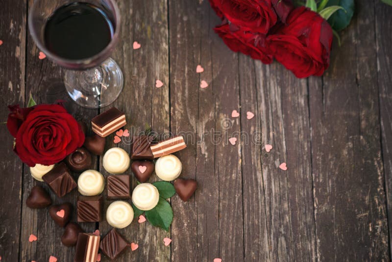 Alter hölzerner Hintergrund mit roten Rosen und Schokoladenpralinen kopieren lizenzfreie stockfotografie Alter hölzerner Hintergrund mit roten Rosen und Schokoladenpralinen kopieren lizenzfreie stockfotografie