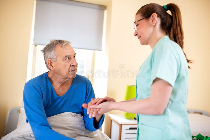 Alter Mann hat durch eine Krankenschwester in älteren Menschen nach Hause teil lizenzfreies stockbild