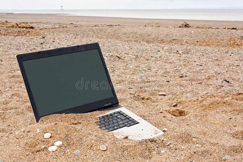 Old or obsolete unwanted laptop on the beach with blank screen for your own message good concept for unwanted technology or travel websites. Old or obsolete unwanted laptop on the beach with blank screen for your own message good concept for unwanted technology or travel websites