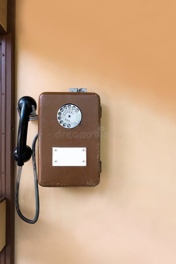 Altes allgemeines Münztelefon auf der Wand Brown-Metalltelefon lizenzfreie stockbilder Altes allgemeines Münztelefon auf der Wand Brown-Metalltelefon lizenzfreie stockbilder