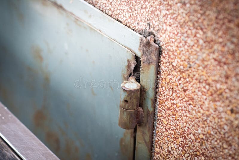 Altes blaues Metallgeschlossene Stahltür mit rotem rostigem Schmutz an der orange Musterwand stockbild Altes blaues Metallgeschlossene Stahltür mit rotem rostigem Schmutz an der orange Musterwand stockbild