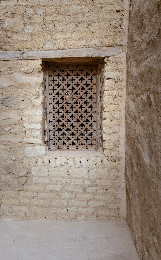 Altes hölzernes Fenster mit dem geometrischen Muster basiert auf dem christlichen Kreuz auf Steinwand des externen Ziegelsteines lizenzfreie stockbilder Altes hölzernes Fenster mit dem geometrischen Muster basiert auf dem christlichen Kreuz auf Steinwand des externen Ziegelsteines lizenzfreie stockbilder