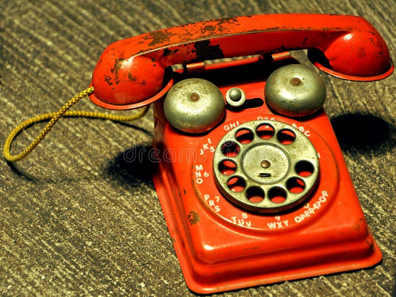 Old red telephone with a dialing wheel. Retro object concept image. Old red telephone with a dialing wheel. Retro object concept image.