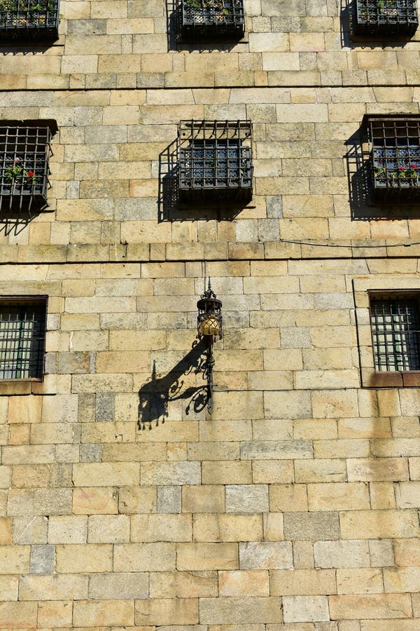 Altes Straßenlaterne in Quintana-Quadrat, nah an Kathedrale Steinwände und Fenster mit Grills Santiago de Compostela, Spanien Sun lizenzfreies stockfoto Altes Straßenlaterne in Quintana-Quadrat, nah an Kathedrale Steinwände und Fenster mit Grills Santiago de Compostela, Spanien Sun lizenzfreies stockfoto