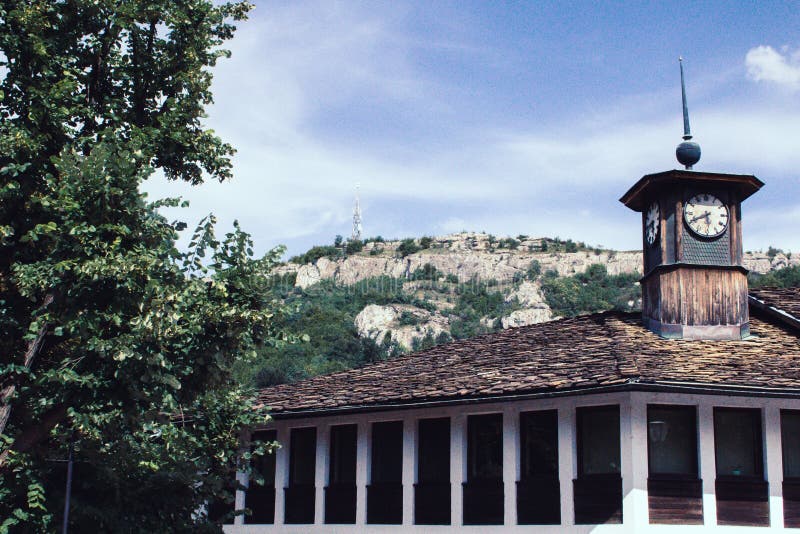 Altes traditionelles Gebäude in Bulgarien mit einem hölzernen Glockenturm und ein Hügel im Hintergrund lizenzfreies stockbild Altes traditionelles Gebäude in Bulgarien mit einem hölzernen Glockenturm und ein Hügel im Hintergrund lizenzfreies stockbild