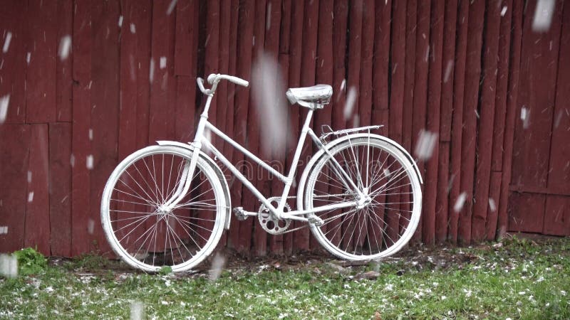 Altes weißes Fahrrad Nähe Scheune in der Farm und im Schneesturm