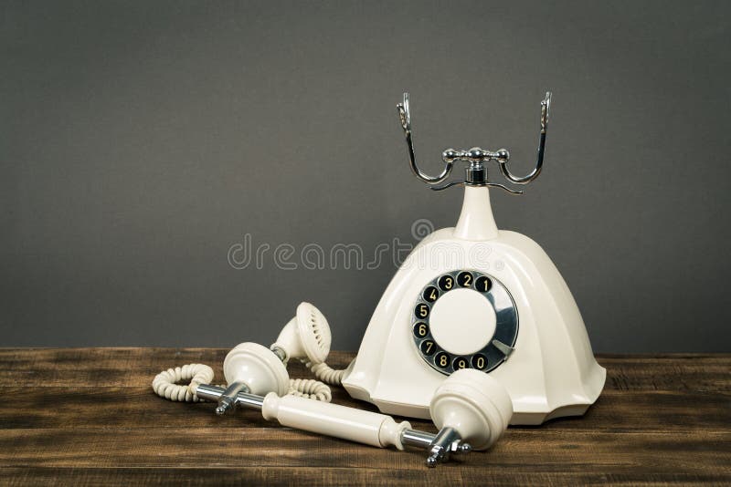 Altes weißes Telefon auf Holztisch mit Farbwandhintergrund stockfotos Altes weißes Telefon auf Holztisch mit Farbwandhintergrund stockfotos