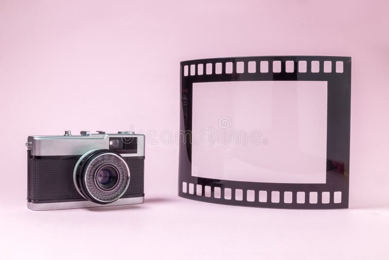 Altmodische Fotografiekamera und Fotorahmen in Form der Filmbandrolle auf einfachem rosa Hintergrund stockbilder Altmodische Fotografiekamera und Fotorahmen in Form der Filmbandrolle auf einfachem rosa Hintergrund stockbilder