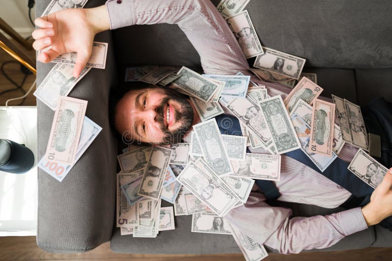 Alto angolo di un uomo felice con molti soldi immagine stock