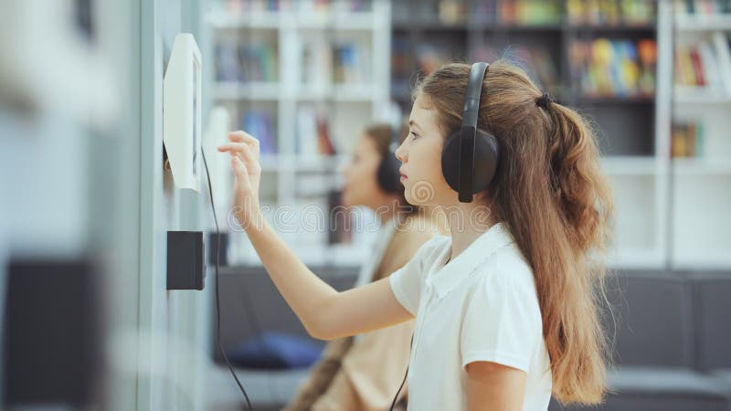 Alunni che utilizzano dispositivi elettronici e cuffie di classe