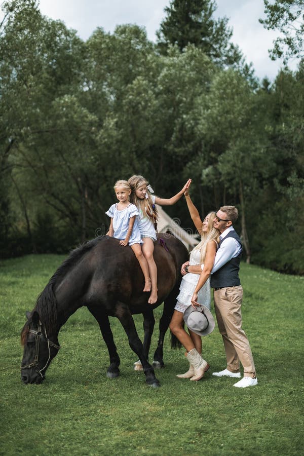 Foto Jovem feliz sorrindo família com cavalo. Família de quatro