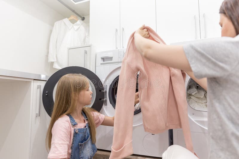 Ama de casa de la madre de la familia e hija felices del niño en lavadero con la lavadora y la ropa imagenes de archivo Ama de casa de la madre de la familia e hija felices del niño en lavadero con la lavadora y la ropa imagenes de archivo