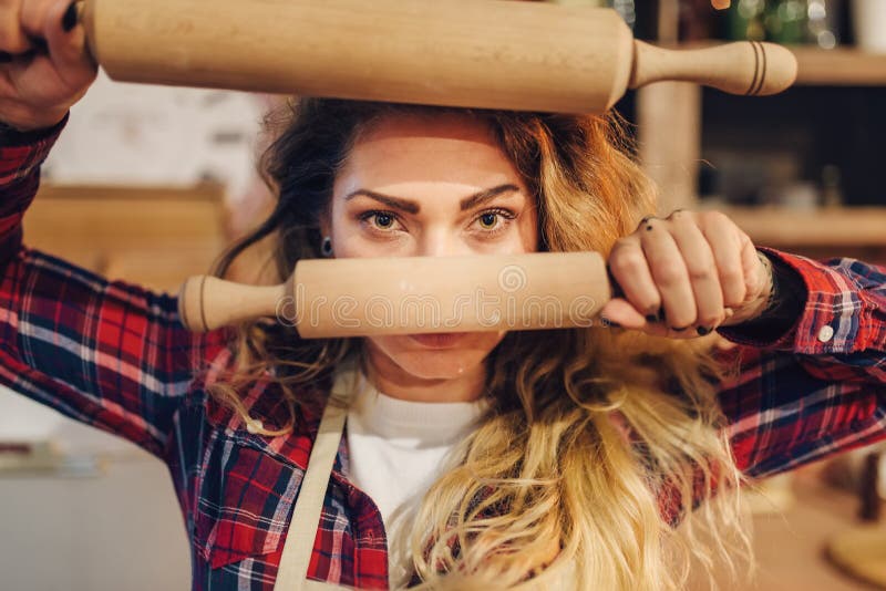 Ama de casa que sostiene los rodillos de madera en manos imagen de archivo Ama de casa que sostiene los rodillos de madera en manos imagen de archivo