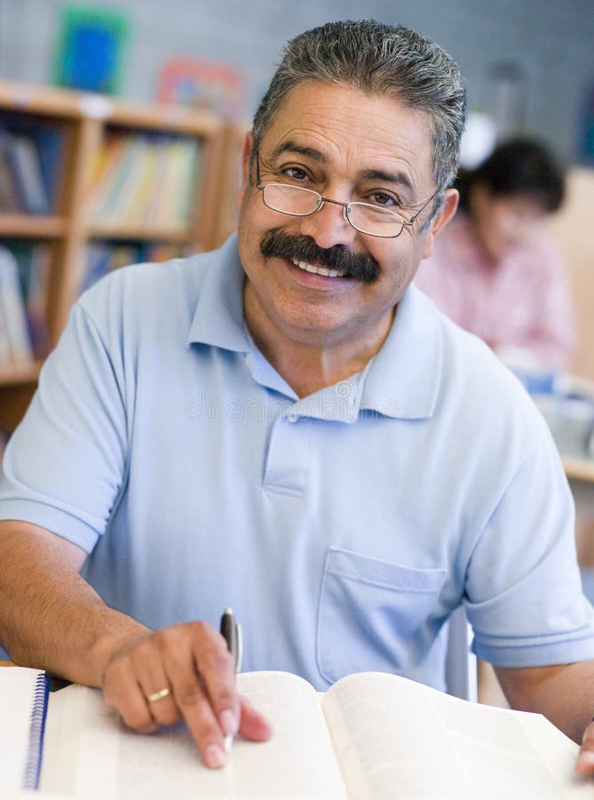 Amadureça o estudante masculino que estuda na biblioteca imagem de stock Amadureça o estudante masculino que estuda na biblioteca imagem de stock