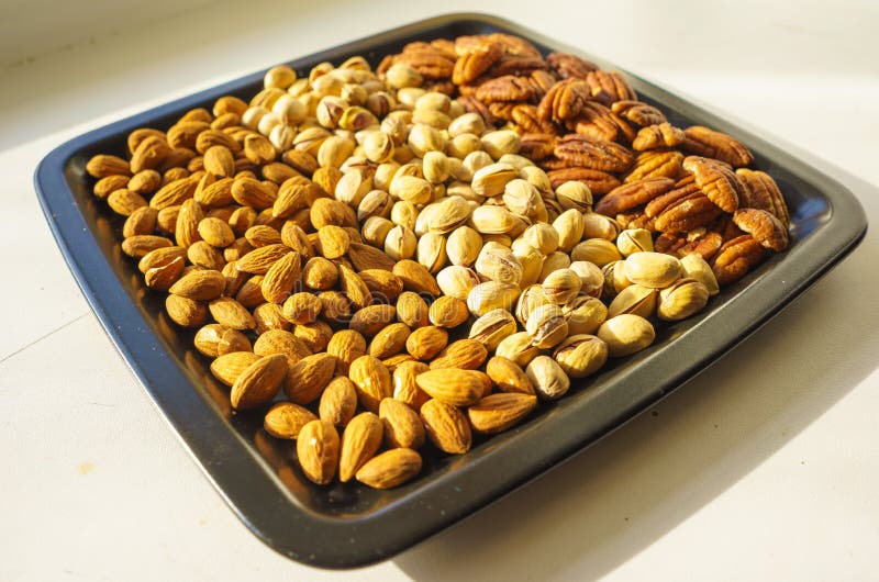 Amandes, pistaches et noix de pécan Nuts de plat noir, plan rapproché, ensemble illustration stock