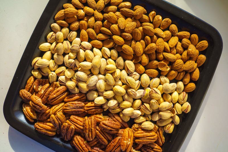 Amandes, pistaches et noix de pécan Nuts de plat noir, plan rapproché, ensemble illustration de vecteur