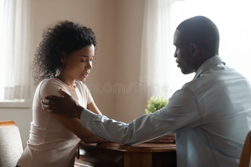 Amando o marido africano americano conforta a esposa triste