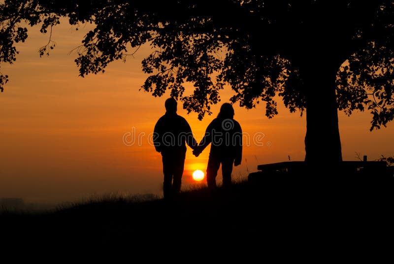 Amants dans le coucher du soleil photos stock Amants dans le coucher du soleil photos stock