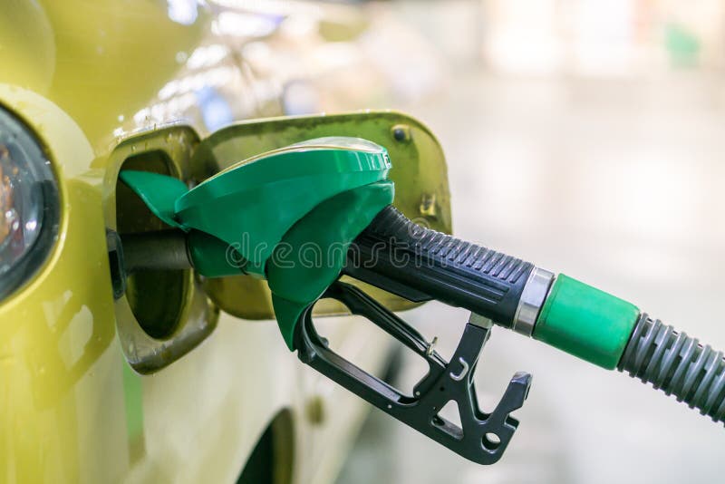 Amarillo, coche del oro en una gasolinera que es llenada del combustible fotografía de archivo Amarillo, coche del oro en una gasolinera que es llenada del combustible fotografía de archivo