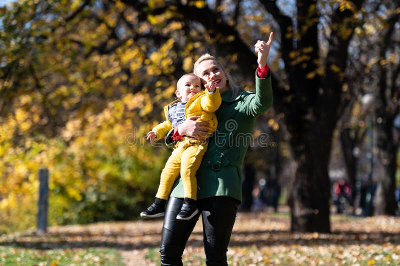Amata mamma che porta il figlio bambino tra i colori autunnali fotografie stock libere da diritti